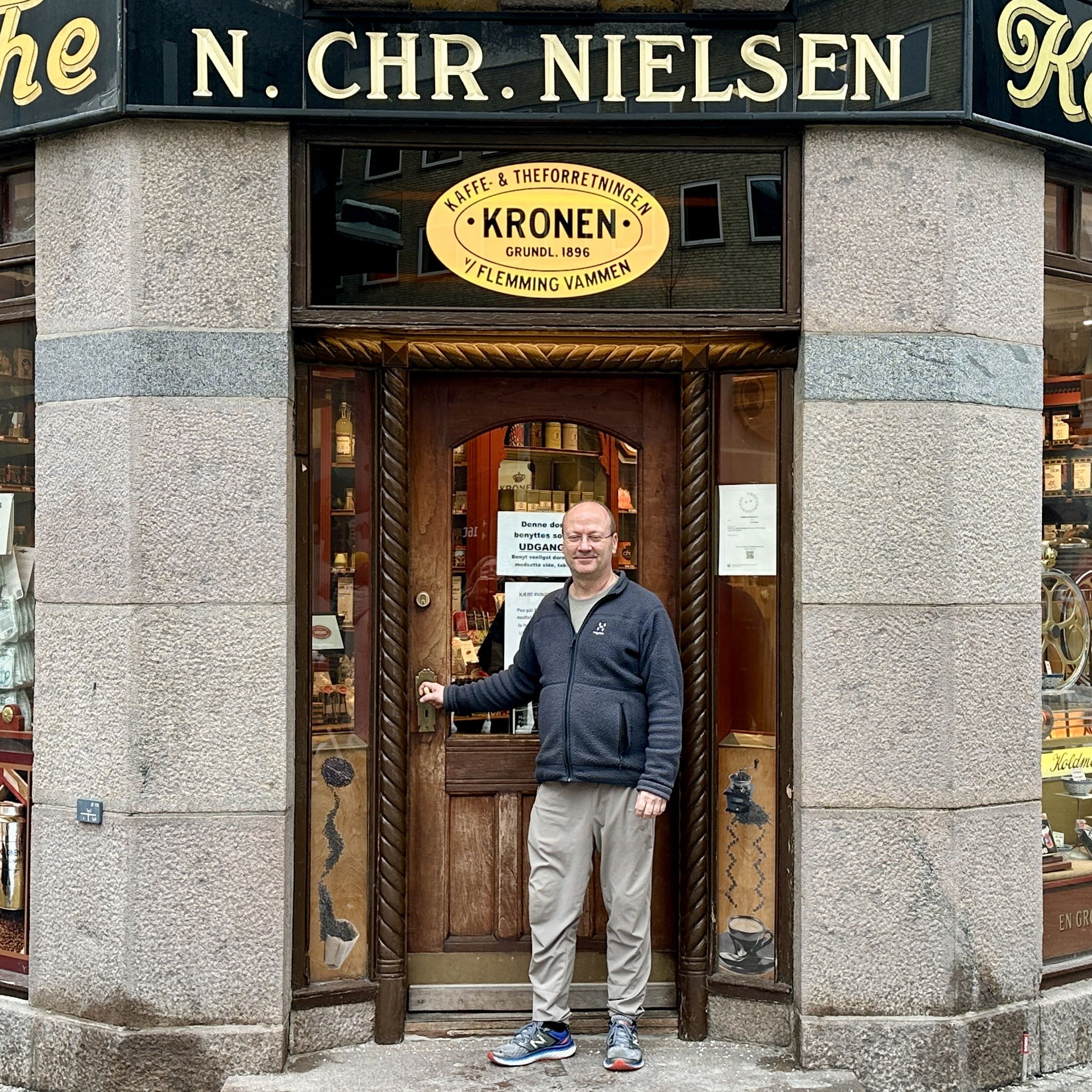 Mand står udenfor gammeldags butik