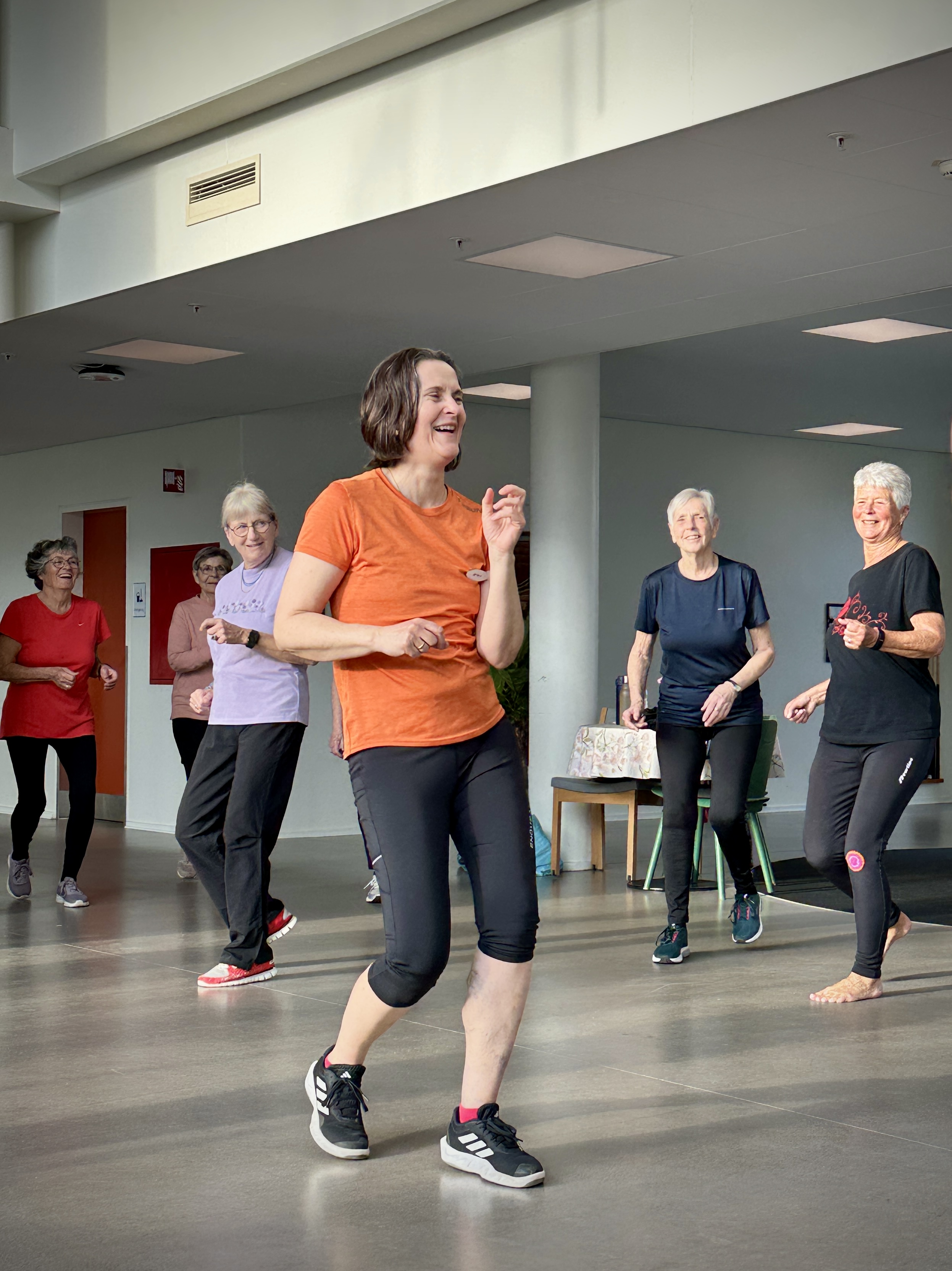 Jette i orange t-shirt inspirerer og leder holdet ”Hverdagsbalance”