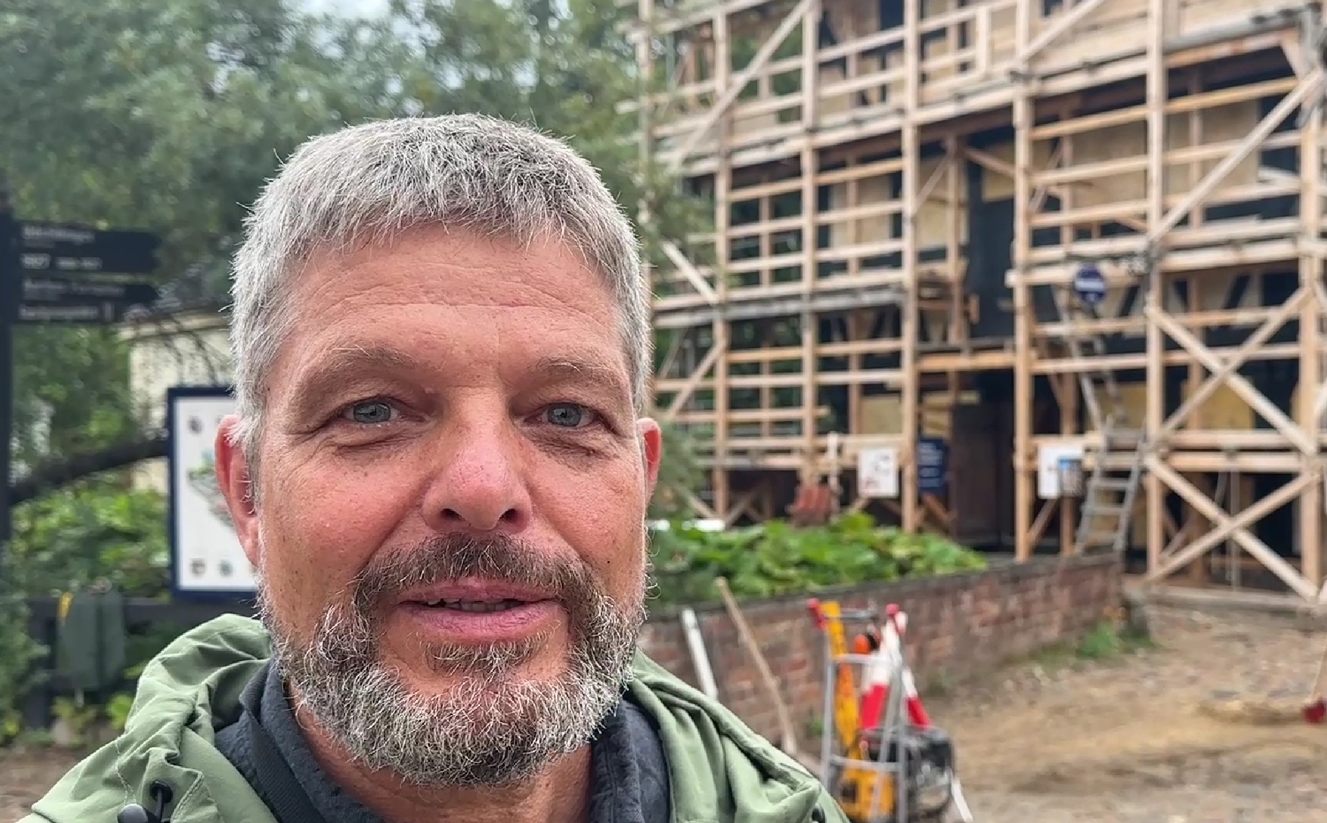 Mand foran hus med stillads