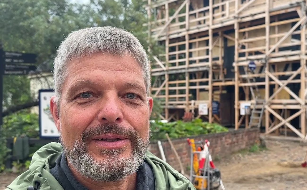 Mand foran hus med stillads