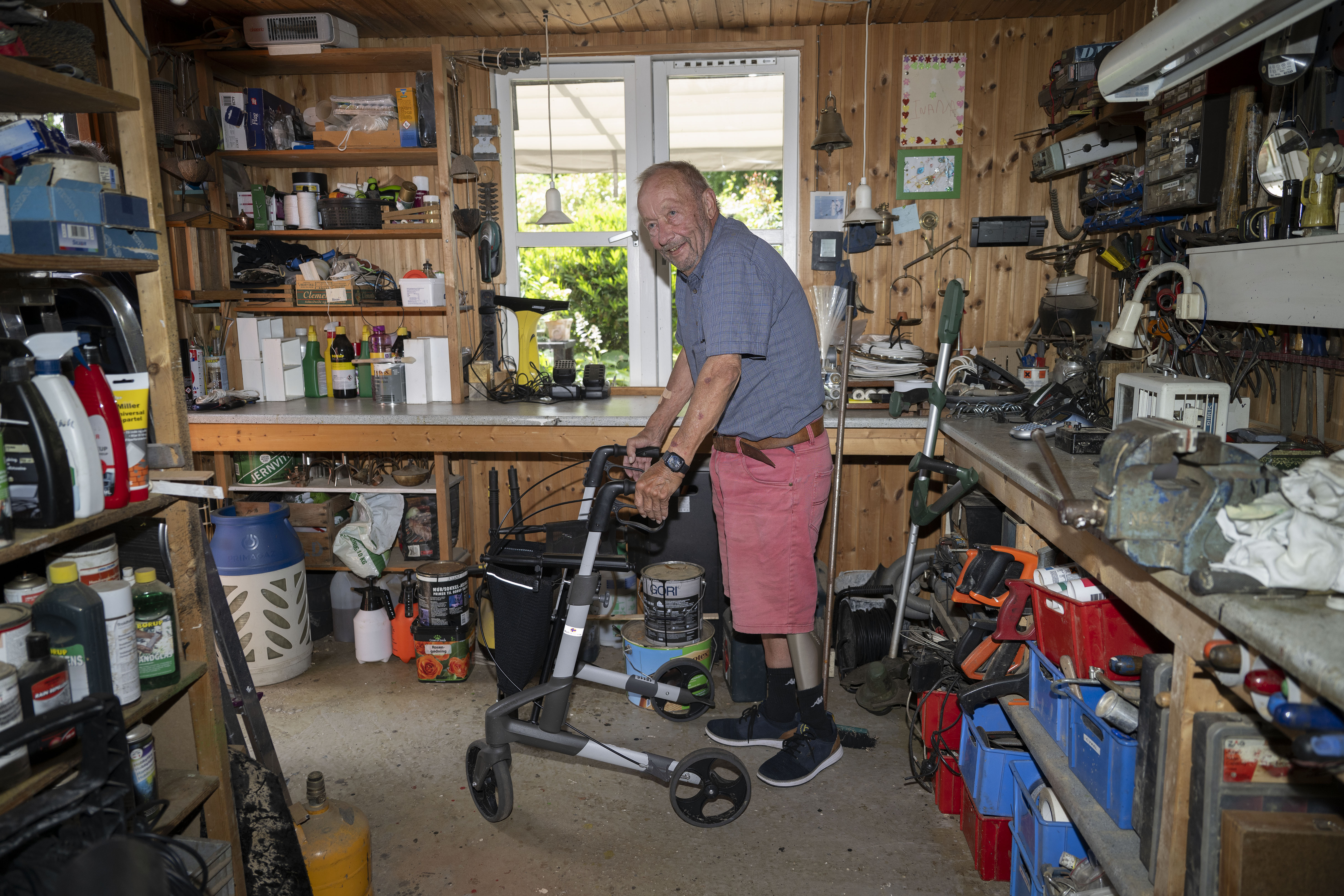 Mand med rollator i værksted