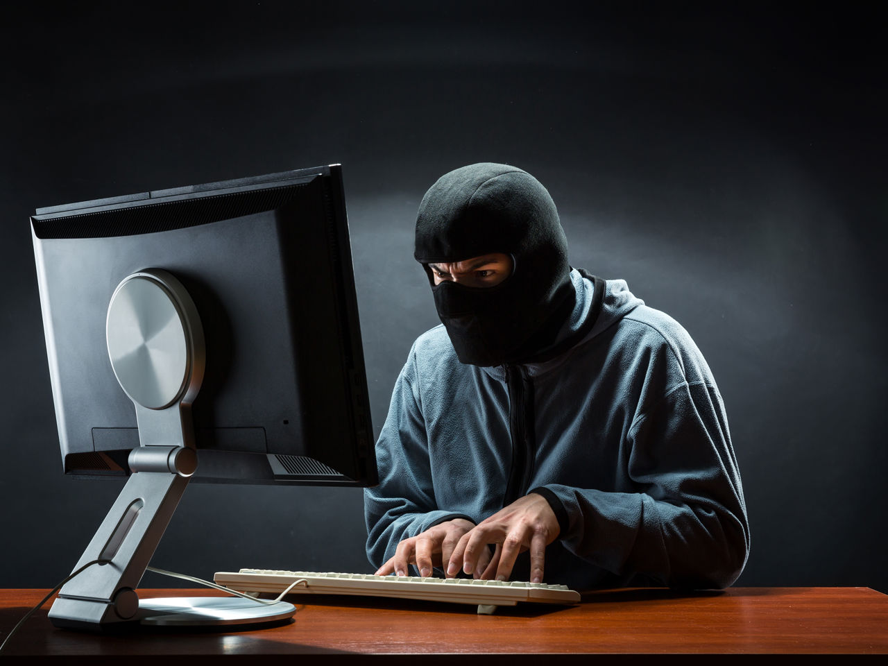 maskeret mand hacker sig ind i computer